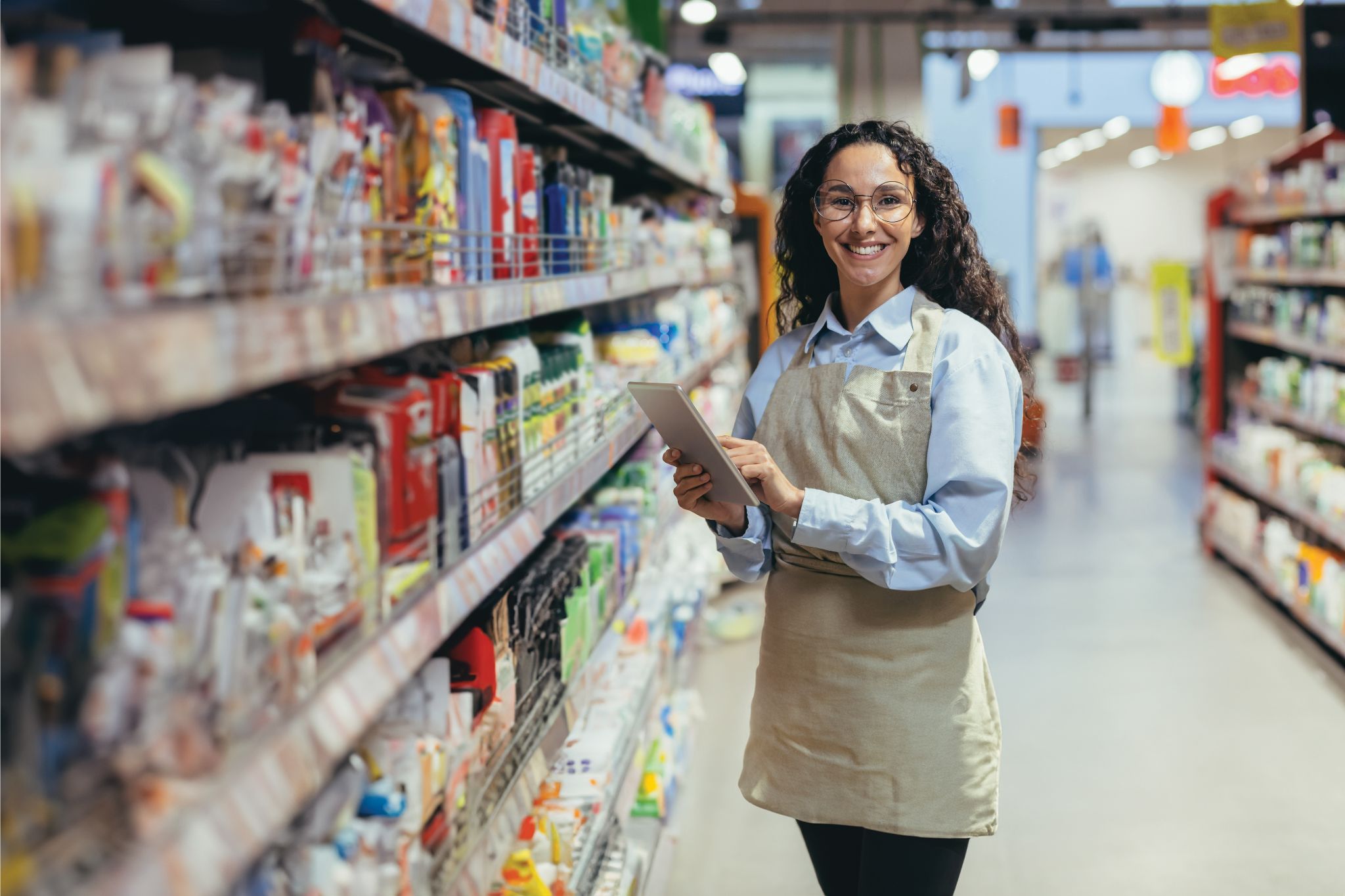 Young lady using ipad in grocery store aisle