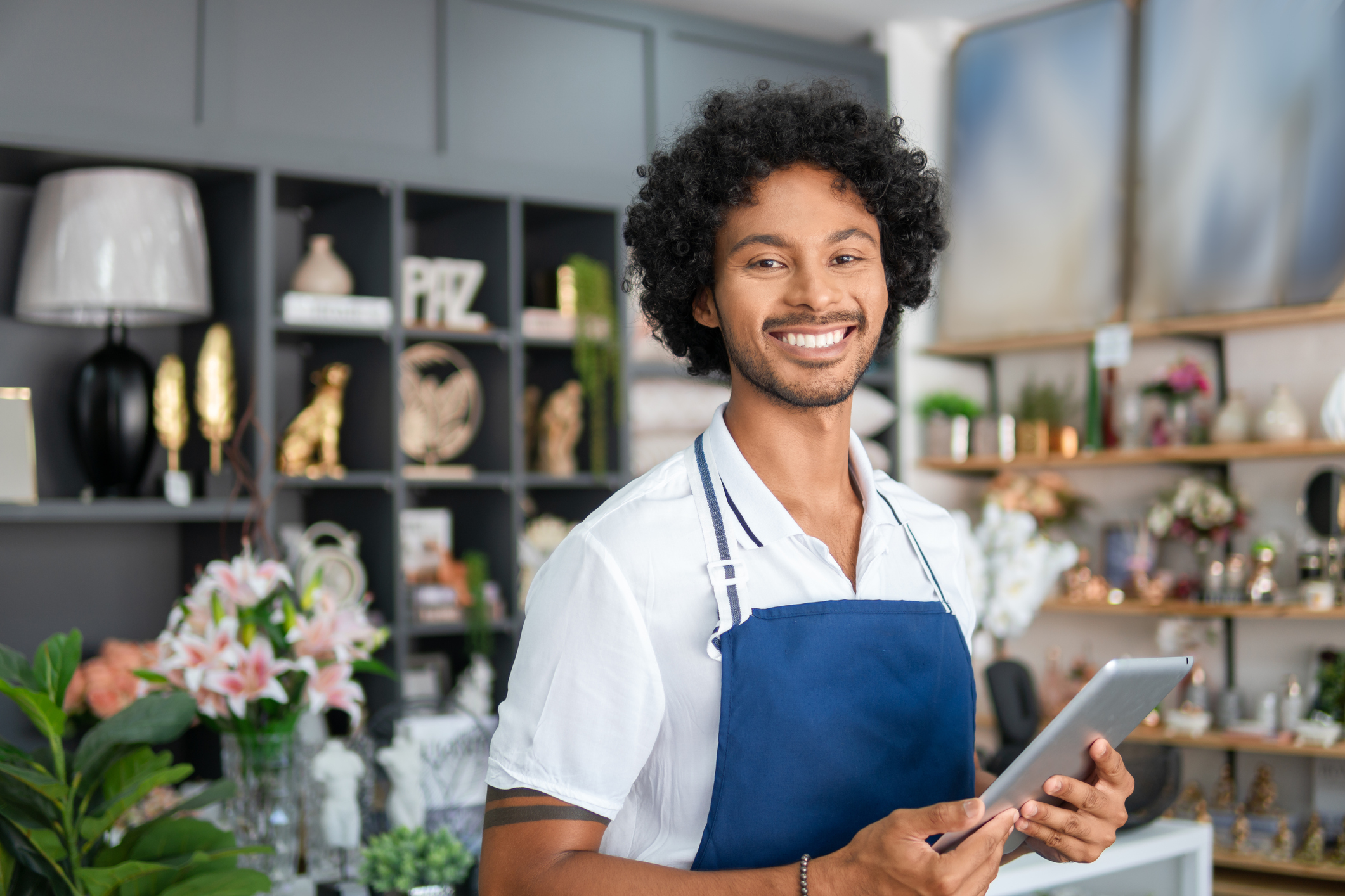 store worker holding an ipad and smiling