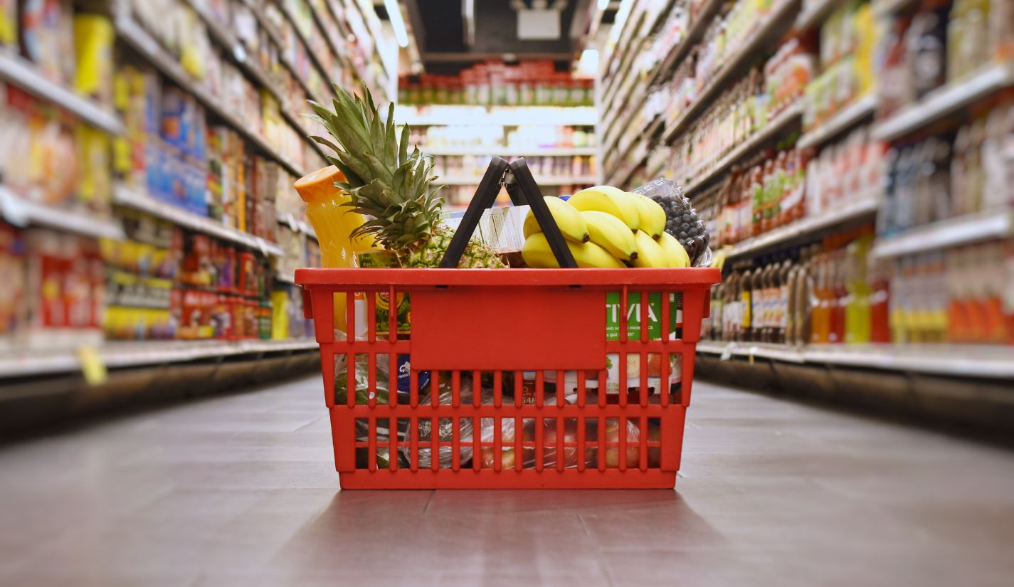 grocery basket in aisle filled with products