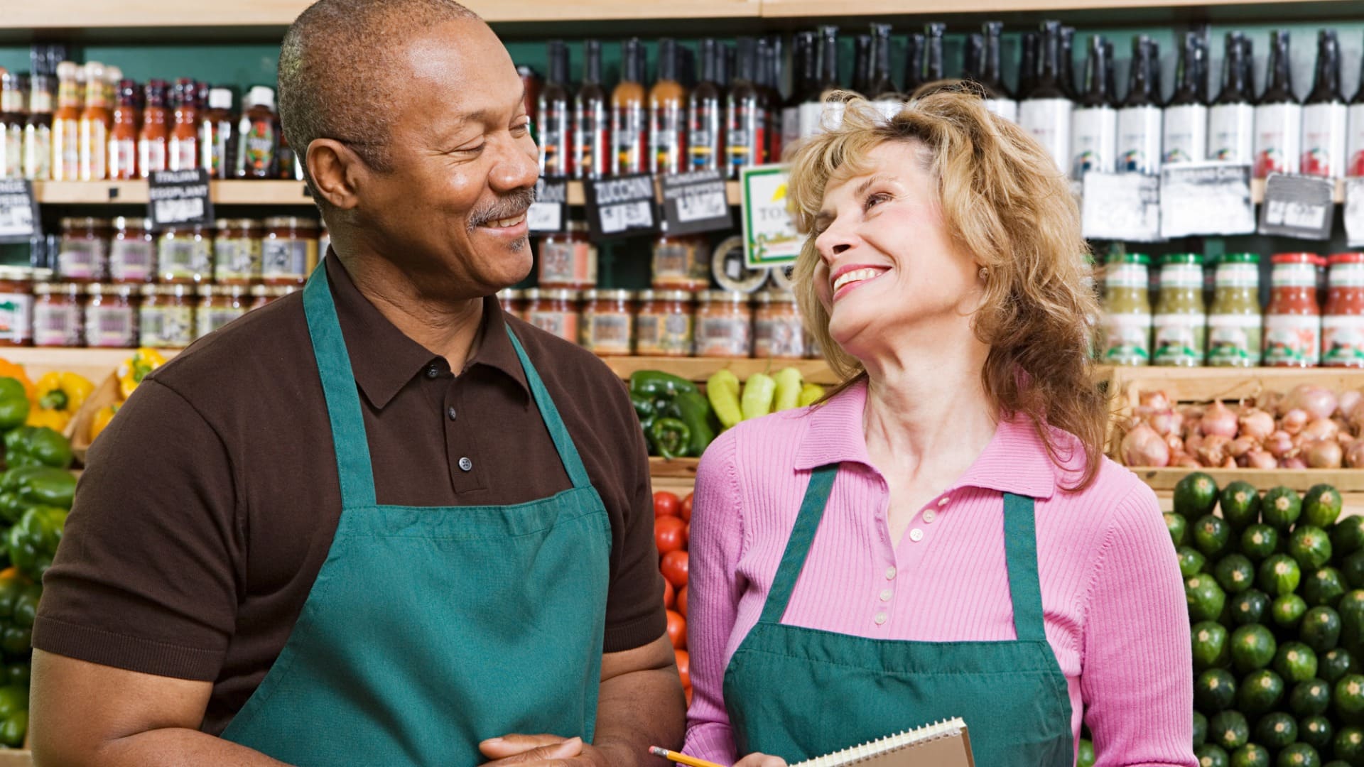 two grocery employees smiling at each other