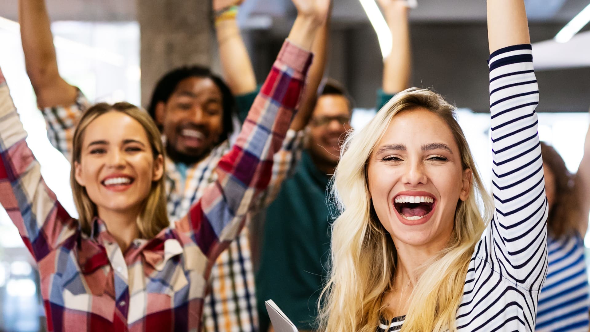 happy smiling employees with arms in the air