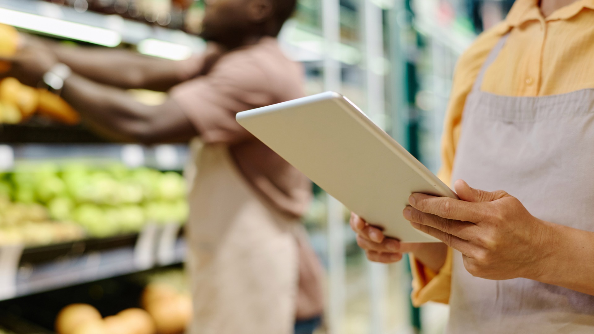 grocery store employee holding a tablet