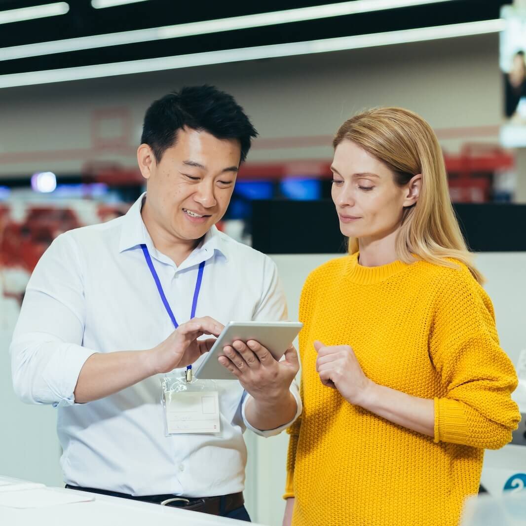 retail worker with tablet helping customer